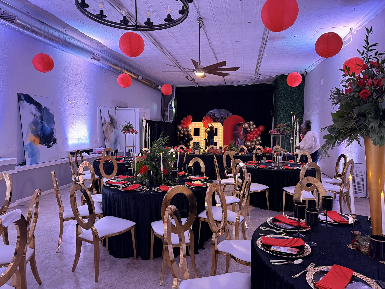 Formal gala in the Atrium with gold chairs, black linens and red décor